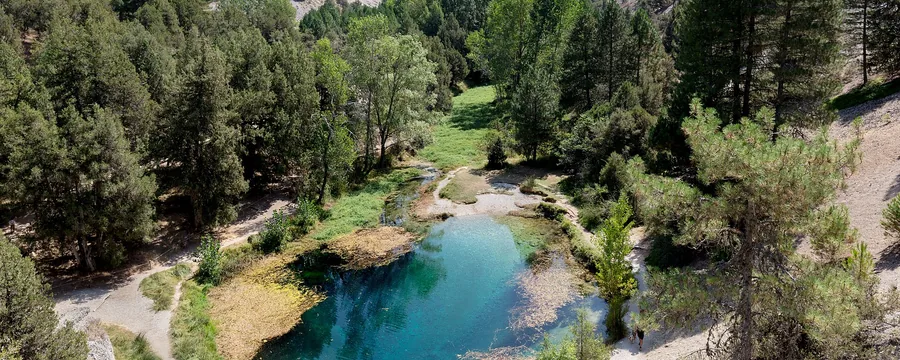 El nacimiento de La Fuentona, un ojo de agua turquesa entre pinos y roquedos
