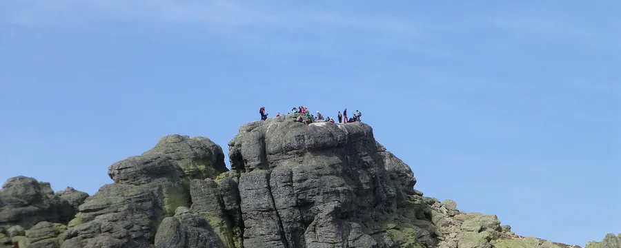 La cumbre rocosa del pico Urbión, con montañeros arriba