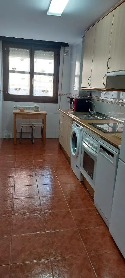 Cocina con la mesa auxiliar, la lavadora y el horno