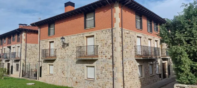 El edificio de piedra y ladrillo donde está el apartamento, con sus balcones de forja